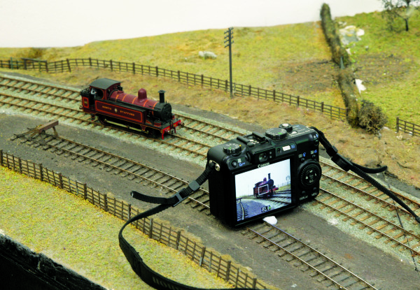 Camera
											 resting across trackwork in front of model locomotive